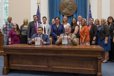 Nevada Governor Joe Lombardo, right, smiles with Nevada Secretary of State Cisco Aguilar after signing an election worker protection bill into law at the old Assembly Chambers in Carson City, Nev., Tuesday, May 30, 2023.